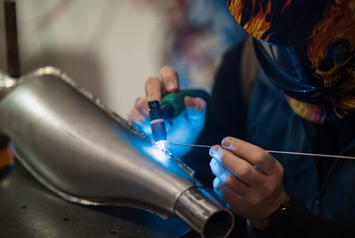 Man fixing a motorcycle in a modern workshop Repairman repair motorcycle, maintenance in garage. Mechanic fixing bike in a modern shop