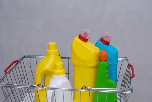 Purchase of household chemicals. Plastic bottles of household chemicals in the shopping basket. Purchase of household chemicals. Different bottles of household chemicals in the shopping basket