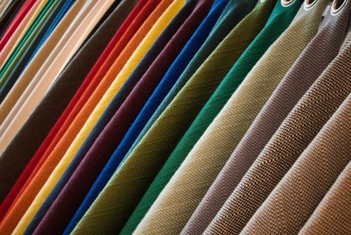 Line of hanging textured fabrics of different colors and shades A line of hanging textured fabrics of different colors and shades