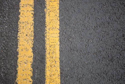 Yellow road marking on road surface, full frame